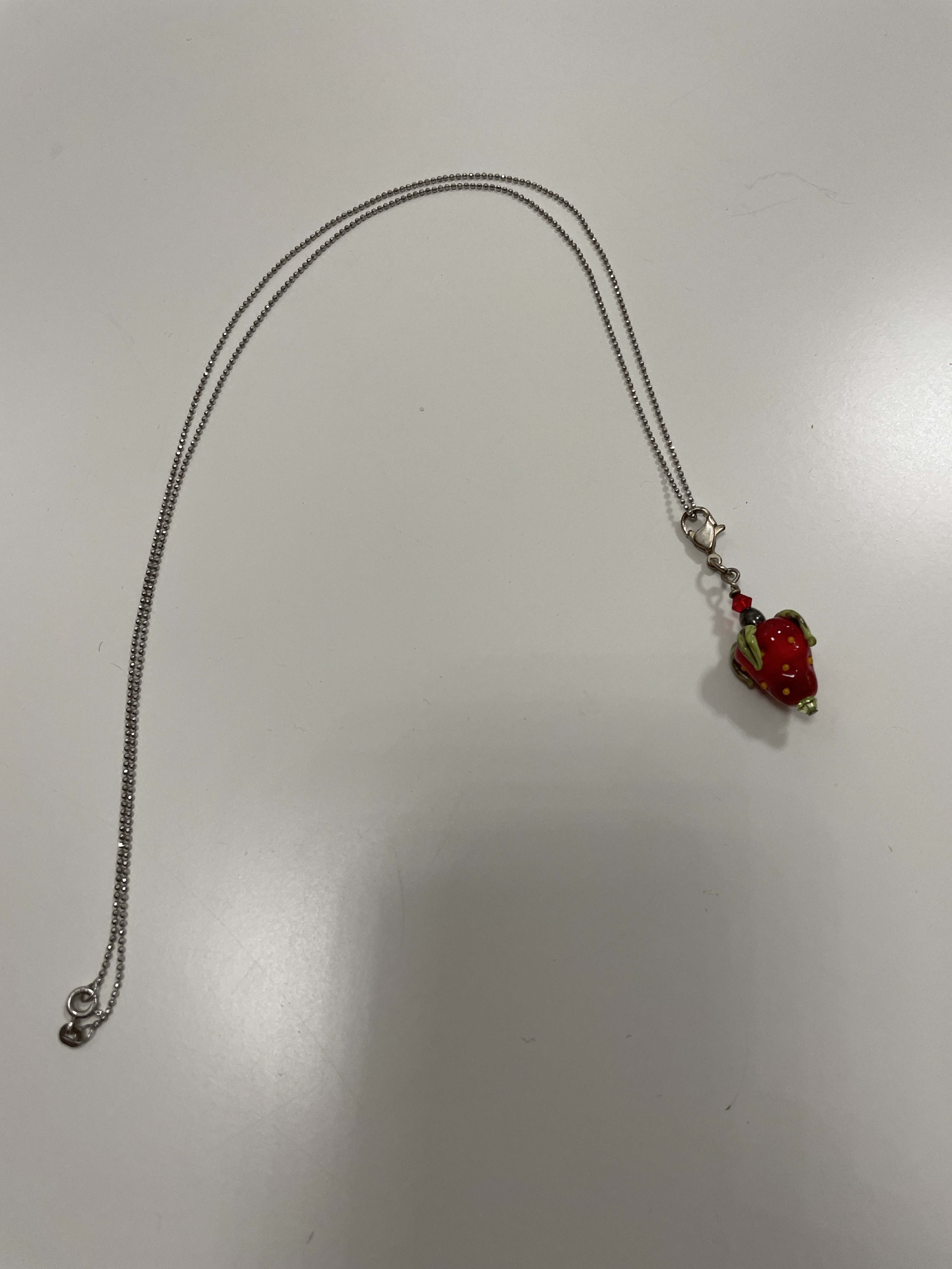 Lange silberfarbene Kette mit Glasanhänger „Erdbeere“
