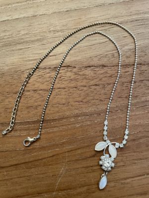 Kurze silberfarbene Modeschmuck-Kette mit floralem Strass-Anhänger